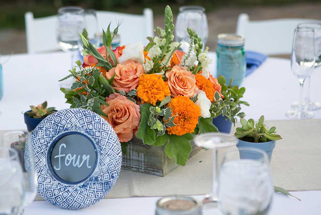 Elegant wedding table setting with orange floral centerpiece