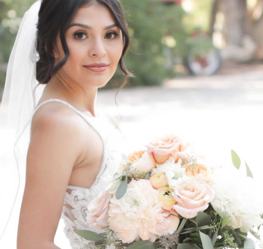 Bride holding a bouquet of peach roses